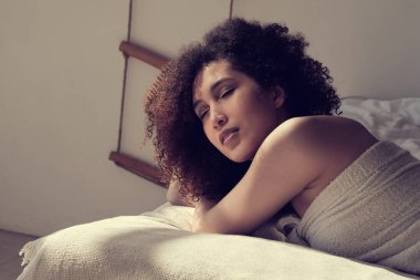 Güzel yüzlü, beyaz dişli, kıvırcık saçlı, kameraya bakıp gülen Afro-Amerikalı bir kadın. Güneş ışınları, yüzünde parıltı. ılık tonlama.