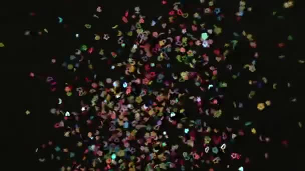 Närbild Confetti explosion på svart bakgrund. Slow Motion konfetti faller video. Flerfärgspartiklar som flyger efter att ha exploderat — Stockvideo