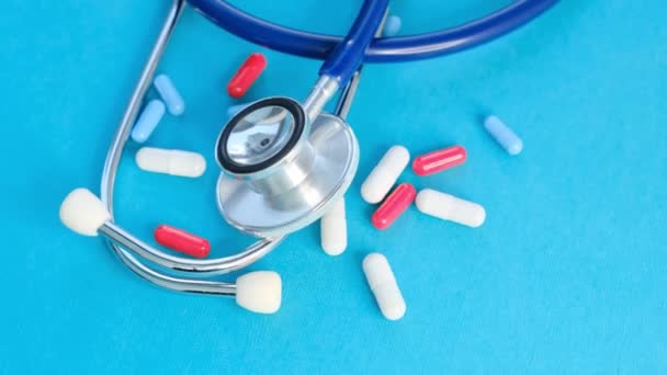 Medical, medicine stethoscope and pills on blue background. Health care or illness. Tablet or drug in hospital or pharmacy. Medication prescription. Slow motion video. stock footage — Stock Video