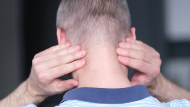 У мужчины средних лет болит шея. Человек в боли с головной болью трения задней части шеи для облегчения — стоковое видео