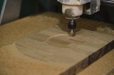Tahta değirmeni. CNC 'deki ahşap panellerin işlenmesi koordine edilmiş marangozluk makineleri. Yavaş çekim videosu. Talaş farklı yönlere dağılır.