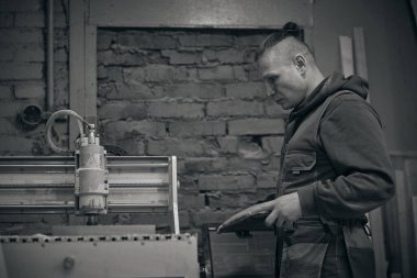 Tahta değirmeni. CNC 'deki ahşap panellerin işlenmesi koordine edilmiş marangozluk makineleri. Yavaş çekim videosu. Talaş farklı yönlere dağılır.