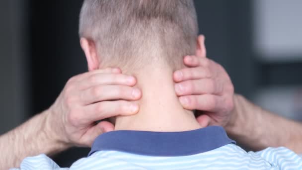 Middle aged male has neck pain. Man in pain with Headache rubbing the back of his neck for relief — Stock Video