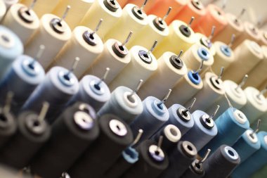 Skeins şeklinde dikiş iplikleri. Bir demet büyük renkli iplik makarası. Daha iyi bir atölye. Makaralara dikmek için renkli iplikler..