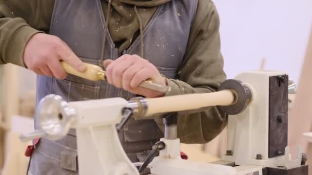 Κλείσε. Ξυλουργός σε εργαστήριο γυαλίζει ξύλινο πίνακα με ηλεκτρικό τροχιακό τριβείο. Έννοια ξυλουργικής και επίπλωσης. — Αρχείο Βίντεο
