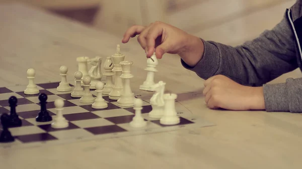 Ett litet barn spelar schack. barn hand gör rätt drag — Stockfoto