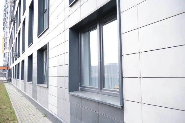 Wand eines Bürogebäudes aus Metallplatten mit Fenstern. Detail moderner Wohnhausfenster auf keramischer hinterlüfteter Fassade. — Stockfoto