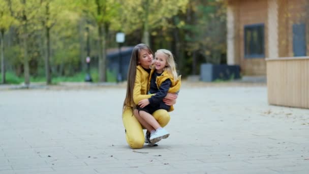 Líbat a objímat šťastnou rodinu. Krásná matka a její dcera venku. Příroda. Krásná máma a její dítě si spolu hrají v parku. video záběry. Zpomalit jemné zaostření — Stock video