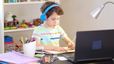 Programından öğren. Uzaktan öğrenme çevrimiçi eğitim. Bir okul çocuğu evde ders çalışır ve okul ödevi yapar. Evden öğrenme.