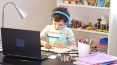 Programından öğren. Uzaktan öğrenme çevrimiçi eğitim. Bir okul çocuğu evde ders çalışır ve okul ödevi yapar. Evden öğrenme.