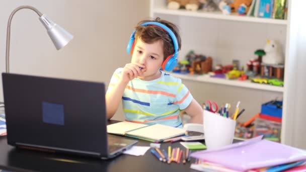 Leer op je schema. Online onderwijs op afstand. Een schooljongen studeert thuis en doet huiswerk op school. Een afstandsonderwijs thuis. — Stockvideo