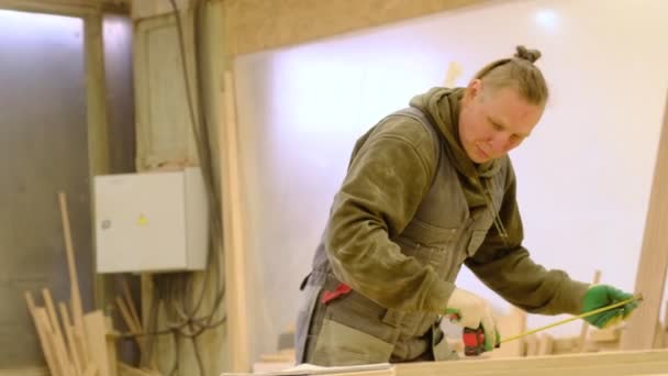 Плотник в мастерской полирует деревянную доску электроорбитальным песком. Концепция производства дерева и мебели. — стоковое видео