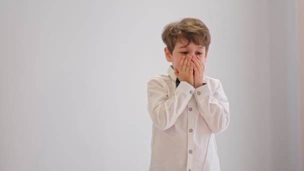 Närbild på ett porträtt av en chockad pojke som rör vid hans ansikte. barndom, uttryck och människors begrepp — Stockvideo