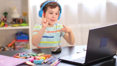 Mutlu çocuk dizüstü bilgisayar dersinden zevk alıyor. Okul çocuğu sıkıcı aktivitelerden bıktı ve ödev yapmayı reddediyor..