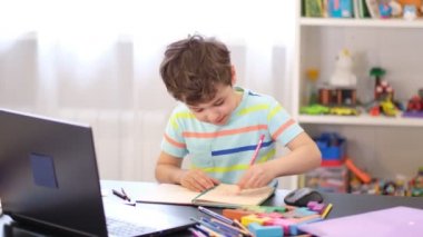 Programından öğren. Uzaktan öğrenme çevrimiçi eğitim. Bir okul çocuğu evde ders çalışır ve okul ödevi yapar. Evden öğrenme.