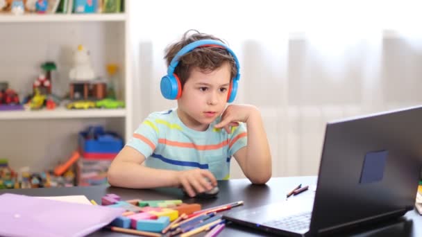 Lär dig enligt ditt schema. Distansutbildning på nätet. En skolpojke studerar hemma och gör läxor. Distansundervisning i hemmet. — Stockvideo