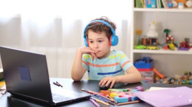 Programından öğren. Uzaktan öğrenme çevrimiçi eğitim. Bir okul çocuğu evde ders çalışır ve okul ödevi yapar. Evden öğrenme.