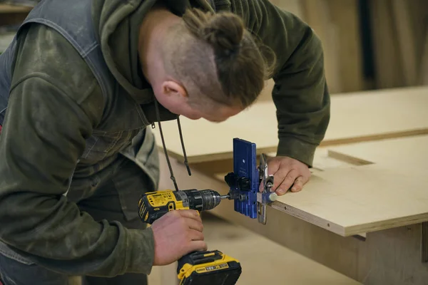 Ferme là. Travail de menuisier dans l'atelier. Concept de menuiserie et de fabrication de meubles. Menuisier dans l'atelier marque et assemble des parties de l'armoire à meubles — Photo