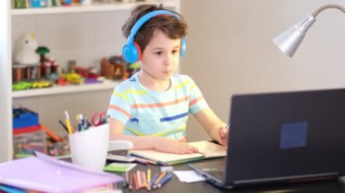 Programından öğren. Uzaktan öğrenme çevrimiçi eğitim. Bir okul çocuğu evde ders çalışır ve okul ödevi yapar. Evden öğrenme.