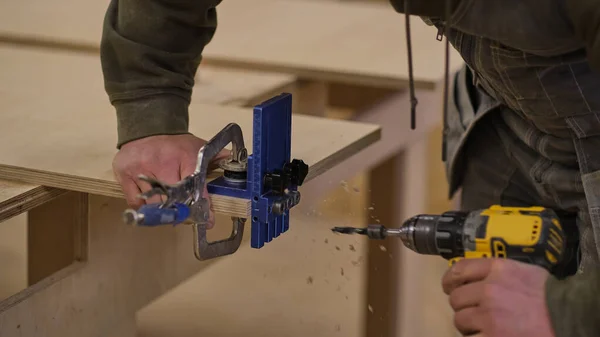 Ferme là. Travail de menuisier dans l'atelier. Concept de menuiserie et de fabrication de meubles. Menuisier dans l'atelier marque et assemble des parties de l'armoire à meubles — Photo