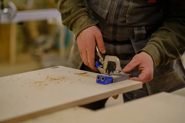 Ferme là. Travail de menuisier dans l'atelier. Concept de menuiserie et de fabrication de meubles. Menuisier dans l'atelier marque et assemble des parties de l'armoire à meubles — Photo