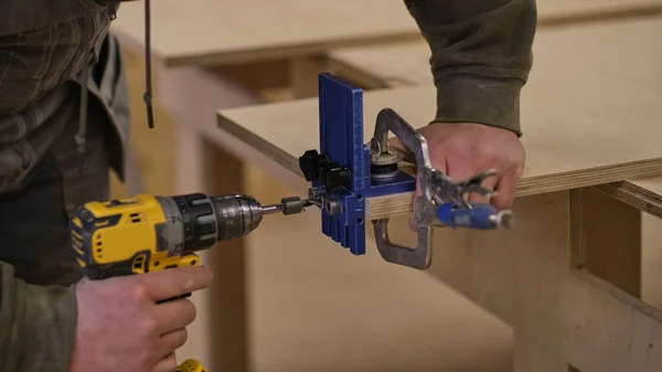 De cerca. Trabajos de carpintería en el taller. Concepto de carpintería y fabricación de muebles. Carpintero en el taller marca y monta partes del gabinete de muebles — Foto de Stock