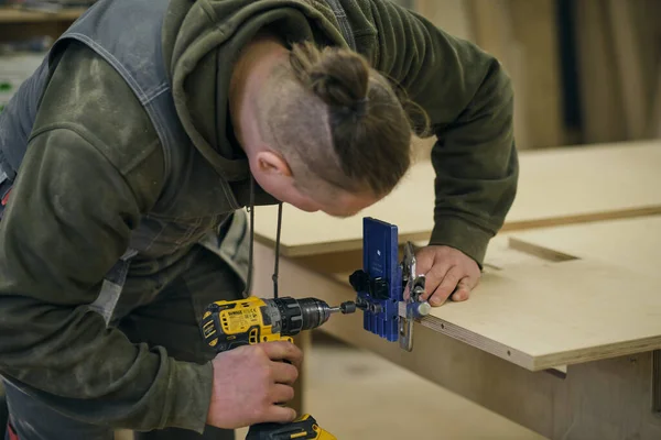 Ferme là. Travail de menuisier dans l'atelier. Concept de menuiserie et de fabrication de meubles. Menuisier dans l'atelier marque et assemble des parties de l'armoire à meubles — Photo