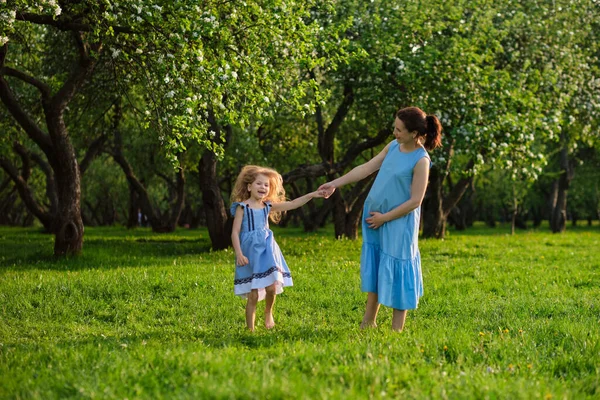 有家庭户外生活方式的自然景观。妈妈和小女儿一起在公园里玩耍。快乐的家庭观念。家庭生活的幸福与和谐. — 图库照片
