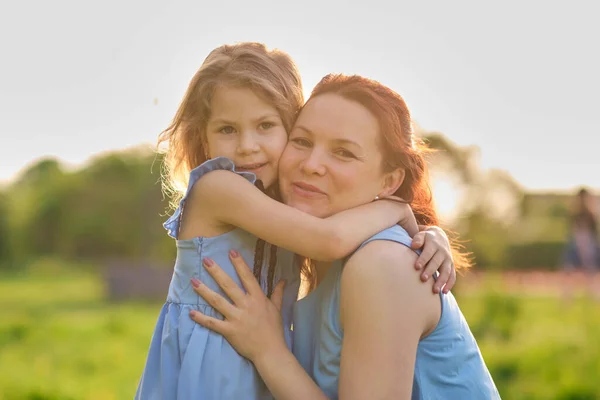 Naturszene mit familiärem Outdoor-Lifestyle. Mutter und kleine Tochter spielen zusammen in einem Park. Glückliches Familienkonzept. Glück und Harmonie im Familienleben. — Stockfoto