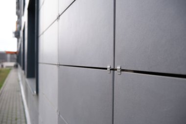 Pencereli metal plakalardan yapılmış ofis binası duvarı. Seramik havalandırmalı cephedeki modern konut pencerelerinin ayrıntıları.