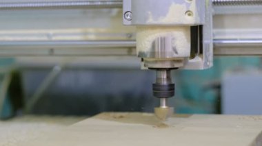 Tahta değirmeni. CNC 'deki ahşap panellerin işlenmesi koordine edilmiş marangozluk makineleri. Yavaş çekim videosu. Talaş farklı yönlere dağılır.