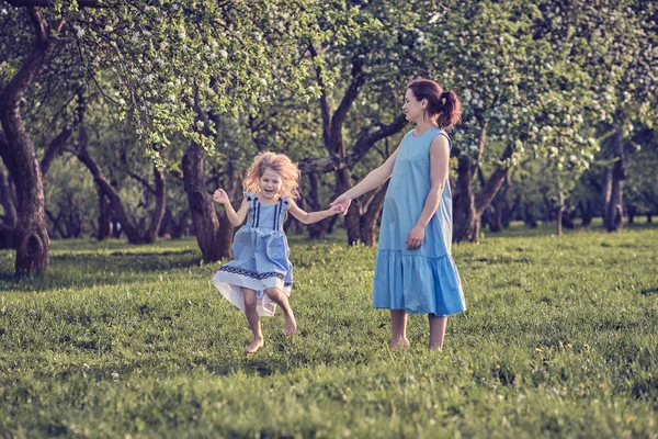 Природная сцена с семейным уличным образом жизни. Мать и маленькая дочь играют вместе в парке. Счастливая семейная концепция. Счастье и гармония в семейной жизни. — стоковое фото