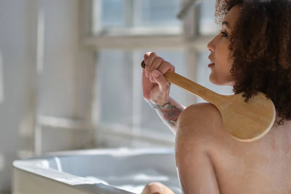 Sorrindo e relaxando afro-americana tomando banho em uma banheira cheia de espuma. Um tempo incrível. conceito de pessoas estilo de vida — Fotografia de Stock