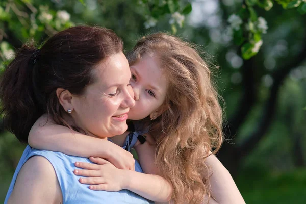 Naturszene mit familiärem Outdoor-Lifestyle. Mutter und kleine Tochter spielen zusammen in einem Park. Glückliches Familienkonzept. Glück und Harmonie im Familienleben. — Stockfoto