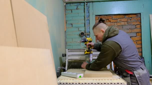 De cerca. Carpintero sosteniendo una cinta métrica en el banco de trabajo. Concepto de carpintería y fabricación de muebles. Carpintero en el taller marca y monta partes del gabinete de muebles — Vídeos de Stock