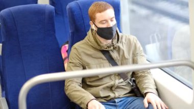 Yakışıklı adam metroda ya da trende giderken kalabalığa mesafeli yaklaşmaya devam ediyor. Enfeksiyon ve hava kirliliğini önleme kavramı