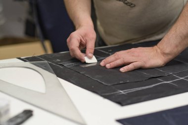 Terzi kadın işyeri. Terzi kadın, terzi stüdyosunda elbise dikmek için tebeşirle desen çiziyor. Terzi atölyesi, el yapımı özel elbiseler dikmek ve tamir etmek. yaratıcı meslek kavramı