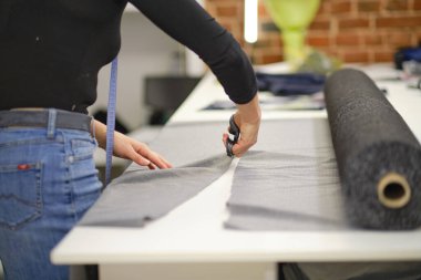 Terzi eskiz çizgisinde kumaş kesiyor. Moda tasarımcısı ya da atölyedeki lağım temizleyicisi yeni koleksiyon giysileri tasarlıyor. Dükkan sahibi ve girişimci konsepti