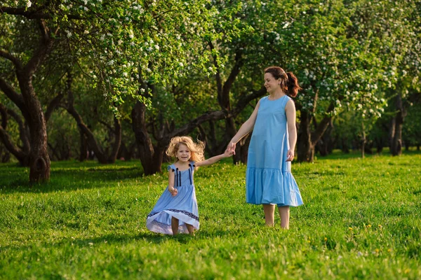 Cena da natureza com estilo de vida familiar ao ar livre. Mãe e filha brincando juntas em um parque. Feliz conceito de família. Felicidade e harmonia na vida familiar. — Fotografia de Stock