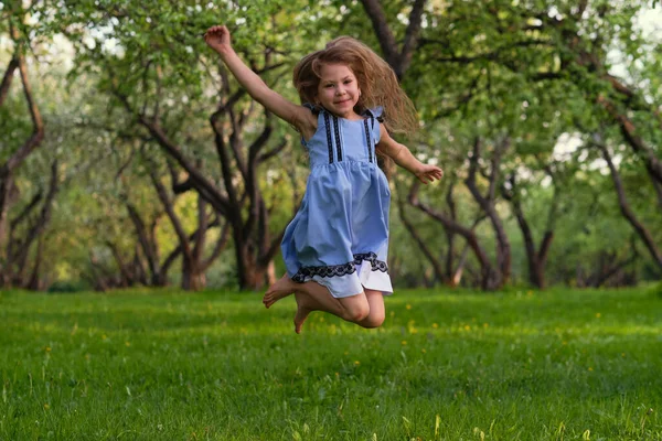 Little girl runs barefoot on the grass. happy child on a hot summer day. — Stock Photo, Image
