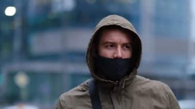 Siyah kapüşonlu yakışıklı adam siyah tıbbi maske takıyor. Pandemik karantina dönemi konsepti.