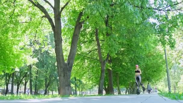 Femme en vêtements de sport trains dans le parc à l'extérieur. Kangoo saute formation. — Video