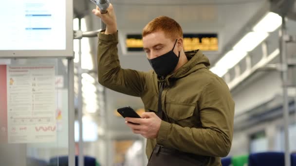 Snygg kille håller sociala avstånd till folkmassan medan pendla i tunnelbanan eller tåget. Begreppet infektion och förebyggande av luftföroreningar — Stockvideo