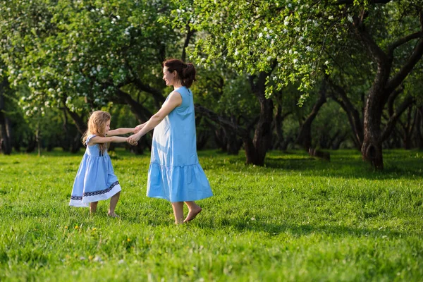 Cena da natureza com estilo de vida familiar ao ar livre. Mãe e filha brincando juntas em um parque. Feliz conceito de família. Felicidade e harmonia na vida familiar. — Fotografia de Stock