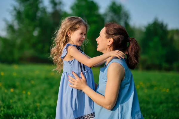 Naturszene mit familiärem Outdoor-Lifestyle. Mutter und kleine Tochter spielen zusammen in einem Park. Glückliches Familienkonzept. Glück und Harmonie im Familienleben. — Stockfoto