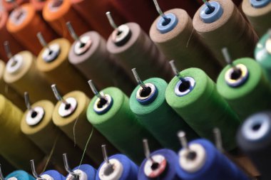 Skeins şeklinde dikiş iplikleri. Bir demet büyük renkli iplik makarası. Daha iyi bir atölye. Makaralara dikmek için renkli iplikler..