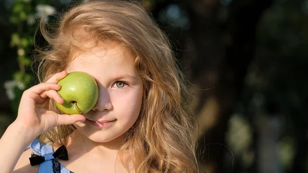 Funny Little girl portrait holding gren apples before her eyes. Healthy eating concept — Stock Photo, Image