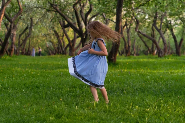 Menina corre descalça na grama. criança feliz em um dia quente de verão. — Fotografia de Stock