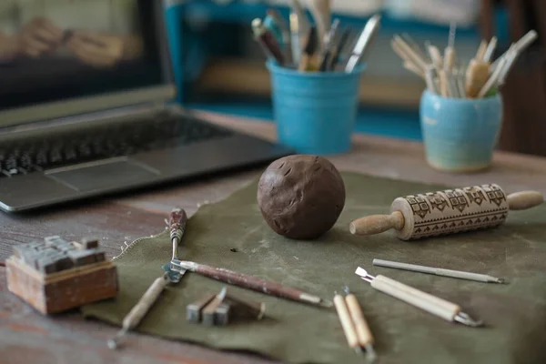 Clay and tools are on the table in front of the laptop. ceramics online training concept. video tutorials for hobbies. Pottery tools — Stock Photo, Image