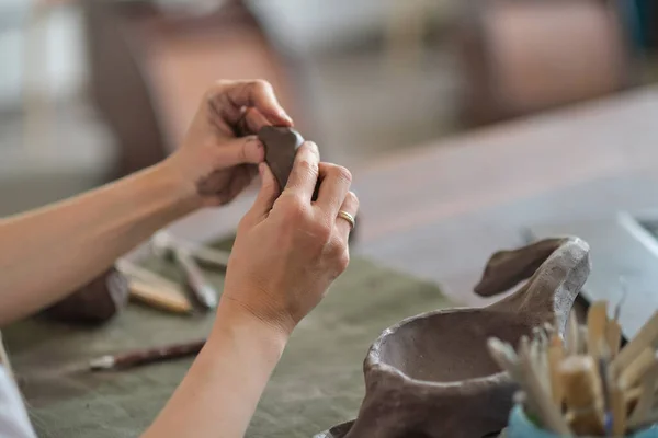 포터 여성은 스튜디오 작업장에서 두 손으로 진흙 조각을 반죽하고 있다. 자기 손으로 진흙으로 만든 도기. — 스톡 사진